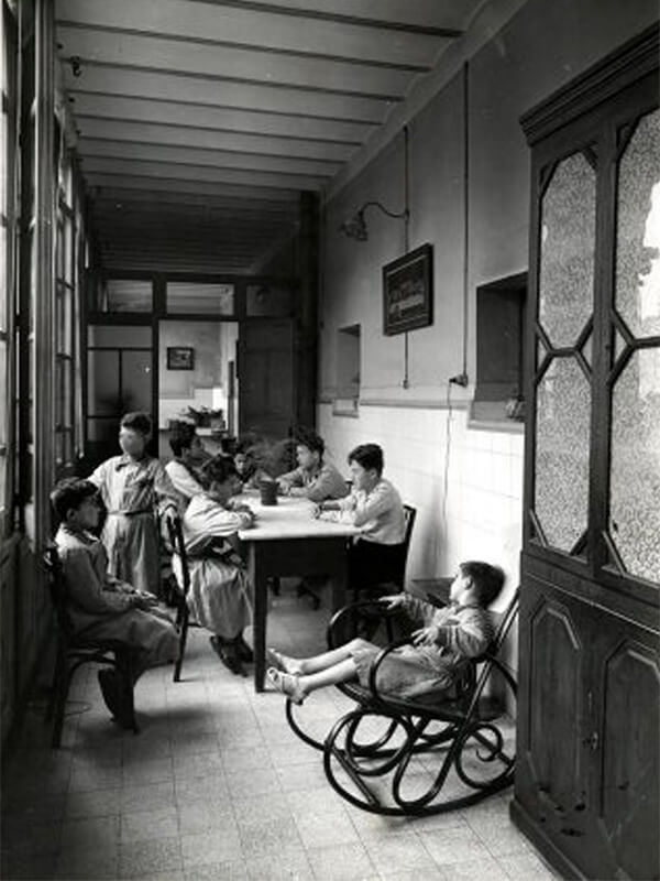 Comedor situado en una galería cerrada por vidrieras de la Casa de Caridad de Barcelona. Años 50. Autor: Joan Francès Estorch. AGDB